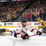Latest NHL News and NHL Scores: Stanley Cup Final Game 4 Recap Jordan Staal, wearing number 11 and a "C" on his white away jersey, falling to the ice while scoring a diving backhand goal with his Bauer stick, against the Vegas Golden Knights in Game 4 of the 2026 Stanley Cup Final. He is sliding towards the right on the ice, and the puck is visibly entering the net on the far right of the photo.