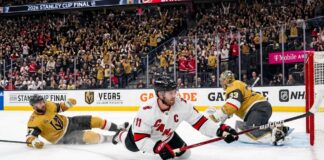Latest NHL News and NHL Scores: Stanley Cup Final Game 4 Recap Jordan Staal, wearing number 11 and a "C" on his white away jersey, falling to the ice while scoring a diving backhand goal with his Bauer stick, against the Vegas Golden Knights in Game 4 of the 2026 Stanley Cup Final. He is sliding towards the right on the ice, and the puck is visibly entering the net on the far right of the photo.