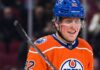 Patrik Laine smiling while wearing an Edmonton Oilers home jersey and blue helmet with visor, visualizing free agency rumors linking him to the Oilers.