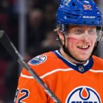 Patrik Laine smiling while wearing an Edmonton Oilers home jersey and blue helmet with visor, visualizing free agency rumors linking him to the Oilers.