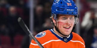 Patrik Laine to Edmonton Oilers: Contract Loophole Explained Patrik Laine smiling while wearing an Edmonton Oilers home jersey and blue helmet with visor, visualizing free agency rumors linking him to the Oilers.