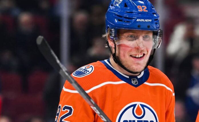Patrik Laine smiling while wearing an Edmonton Oilers home jersey and blue helmet with visor, visualizing free agency rumors linking him to the Oilers.
