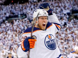 Conceptual action photo of NHL player Patrik Laine celebrating wildly in an Edmonton Oilers white away jersey and helmet, illustrating potential Free Agency landing spots for the pending UFA.