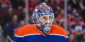 Edmonton Oilers Trade Rumors: Montreal Canadiens Goalie Samuel Montembeault Detailed photo illustration of Montreal Canadiens goalie Samuel Montembeault, looking intense from his crease, with his mask and gear custom-edited to display prominent Edmonton Oilers logos and team colors, visualizing ongoing NHL trade rumors.