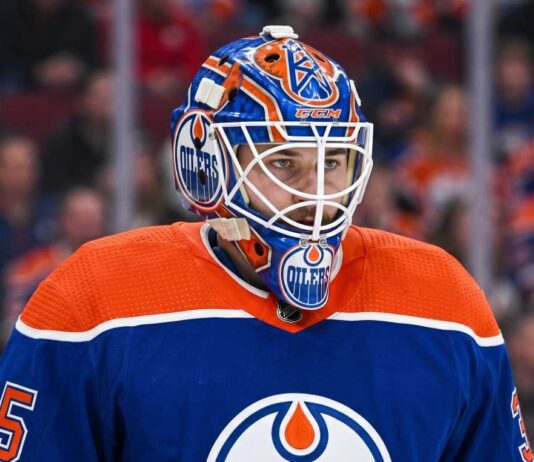 Edmonton Oilers Trade Rumors: Montreal Canadiens Goalie Samuel Montembeault Detailed photo illustration of Montreal Canadiens goalie Samuel Montembeault, looking intense from his crease, with his mask and gear custom-edited to display prominent Edmonton Oilers logos and team colors, visualizing ongoing NHL trade rumors.