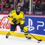 Why the Seattle Kraken Should Draft Viggo Bjorck #7 Overall | Stats & Fit Viggo Björck, a top prospect for the Seattle Kraken in the 2026 NHL Draft, skating with the puck in his yellow Team Sweden number 21 jersey during an international game.
