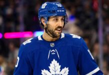 An action shot of Vincent Trocheck wearing a blue Toronto Maple Leafs jersey and helmet, skating on the ice at Scotiabank Arena in this conceptual trade rumor image.
