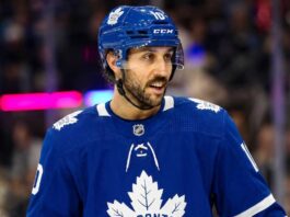 An action shot of Vincent Trocheck wearing a blue Toronto Maple Leafs jersey and helmet, skating on the ice at Scotiabank Arena in this conceptual trade rumor image.