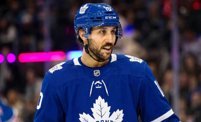 An action shot of Vincent Trocheck wearing a blue Toronto Maple Leafs jersey and helmet, skating on the ice at Scotiabank Arena in this conceptual trade rumor image.