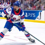 USNTDP forward Wyatt Cullen, a top 2026 NHL Draft prospect for the Nashville Predators, controls the puck during a game.