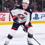 Zach Werenski Trade Rumors: Will the Columbus Blue Jackets Move Him? Zach Werenski, Columbus Blue Jackets star defenseman, during an NHL game, seen in his white away jersey. The photo captures him looking ahead, the primary focus of growing trade speculation for the team.