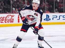 Zach Werenski Trade Rumors: Will the Columbus Blue Jackets Move Him? Zach Werenski, Columbus Blue Jackets star defenseman, during an NHL game, seen in his white away jersey. The photo captures him looking ahead, the primary focus of growing trade speculation for the team.