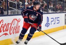 Will Zach Werenski Request a Trade From the Columbus Blue Jackets? Columbus Blue Jackets defenseman Zach Werenski skating in action during an NHL game, the subject of recent trade rumors regarding his future in Columbus.