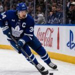 Auston Matthews Point Projections 2026-27: Can He Reach 95 Points? Auston Matthews skating in a Toronto Maple Leafs home jersey with the captain’s C during the 2026-27 NHL season.