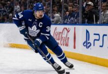 Auston Matthews Point Projections 2026-27: Can He Reach 95 Points? Auston Matthews skating in a Toronto Maple Leafs home jersey with the captain’s C during the 2026-27 NHL season.