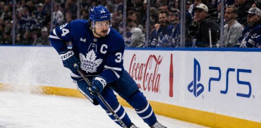Auston Matthews Point Projections 2026-27: Can He Reach 95 Points? Auston Matthews skating in a Toronto Maple Leafs home jersey with the captain’s C during the 2026-27 NHL season.