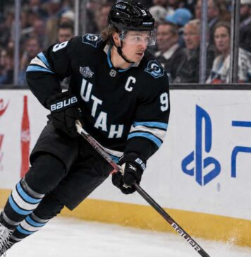 Clayton Keller Point Projections 2026-27: Is a 95-Point Season Coming? Clayton Keller skating in a Utah Mammoth home jersey during a 2026-27 fantasy hockey projection predicting 30 goals, 65 assists and 95 points.