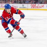 Cole Caufield Fantasy Hockey Projection: Goals, Assists and Points for 2026-27 Cole Caufield skating in a Montreal Canadiens home jersey beside Coca-Cola and PS5 board ads for a 2026-27 Fantasy Hockey projection.