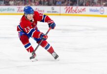 Cole Caufield skating in a Montreal Canadiens home jersey beside Coca-Cola and PS5 board ads for a 2026-27 Fantasy Hockey projection.