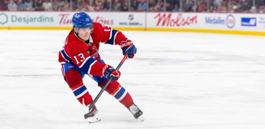 Cole Caufield Fantasy Hockey Projection: Goals, Assists and Points for 2026-27 Cole Caufield skating in a Montreal Canadiens home jersey beside Coca-Cola and PS5 board ads for a 2026-27 Fantasy Hockey projection.
