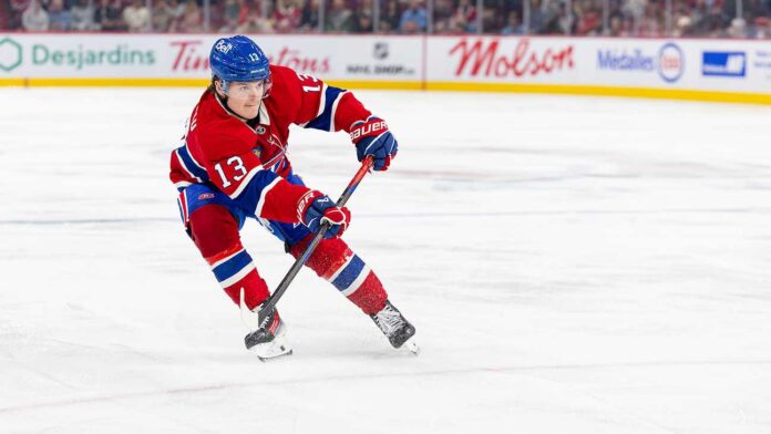 cole-caufield-montreal-canadiens-fantasy-hockey-2026-27 Cole Caufield skating in a Montreal Canadiens home jersey beside Coca-Cola and PS5 board ads for a 2026-27 Fantasy Hockey projection.
