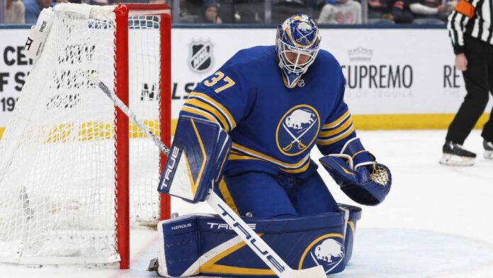 connor-hellebuyck-buffalo-sabres-trade-rumors-2026 Connor Hellebuyck wearing a Buffalo Sabres home uniform and matching goalie equipment amid trade rumors involving the Winnipeg Jets.