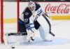 Winnipeg Jets Rumors: Will Connor Hellebuyck Be Traded After Stuart Skinner Signing? Connor Hellebuyck in Winnipeg Jets gear with Coca-Cola board ad as trade rumors link the Jets goalie to the Sabres and Hurricanes