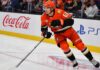 Does Cutter Gauthier Want Leo Carlsson’s $18 Million Contract From the Anaheim Ducks? Cutter Gauthier skating for the Anaheim Ducks beside Coca-Cola and PS5 rink-board ads amid NHL contract rumors