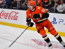 Does Cutter Gauthier Want Leo Carlsson’s $18 Million Contract From the Anaheim Ducks? Cutter Gauthier skating for the Anaheim Ducks beside Coca-Cola and PS5 rink-board ads amid NHL contract rumors