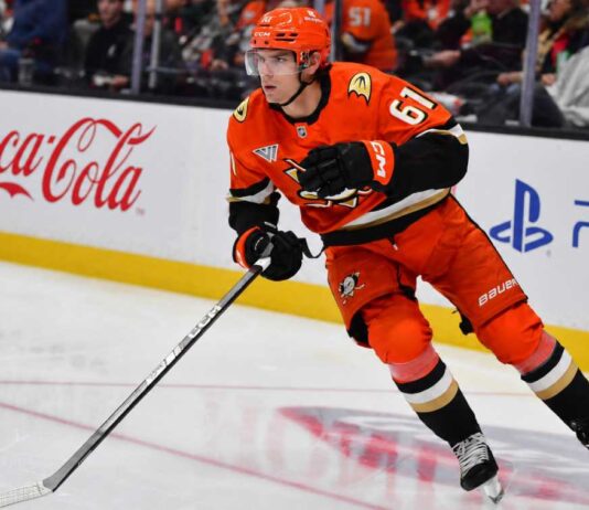 Does Cutter Gauthier Want Leo Carlsson’s $18 Million Contract From the Anaheim Ducks? Cutter Gauthier skating for the Anaheim Ducks beside Coca-Cola and PS5 rink-board ads amid NHL contract rumors