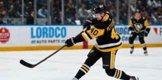 Elias Pettersson wearing a Pittsburgh Penguins home jersey while taking a powerful shot during an NHL game