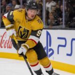Jack Eichel Fantasy Hockey Projection: Will He Reach 100 Points in 2026-27? Jack Eichel skating for the Vegas Golden Knights beside Coca-Cola and PS5 rink-board ads during his projected 2026-27 Fantasy Hockey season.
