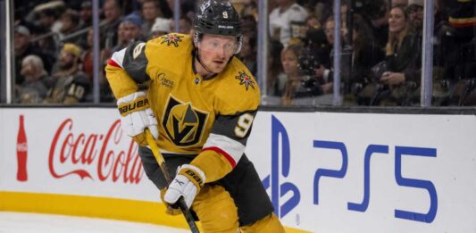 Jack Eichel Fantasy Hockey Projection: Will He Reach 100 Points in 2026-27? Jack Eichel skating for the Vegas Golden Knights beside Coca-Cola and PS5 rink-board ads during his projected 2026-27 Fantasy Hockey season.