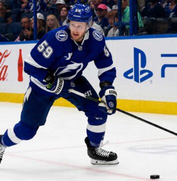 Jake Guentzel Fantasy Hockey Projection: How Many Points Will He Score in 2026-27? Jake Guentzel skating for the Tampa Bay Lightning during a 2026-27 Fantasy Hockey projection with Coca-Cola and PS5 ads on the boards.