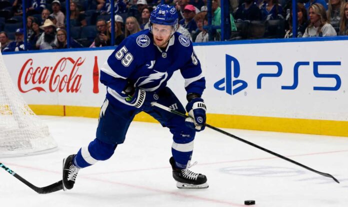 Jake Guentzel skating for the Tampa Bay Lightning during a 2026-27 Fantasy Hockey projection with Coca-Cola and PS5 ads on the boards.