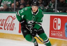 Jason Robertson skating in a Dallas Stars home jersey beside Coca-Cola and Nintendo Switch rink board ads for his 2026-27 fantasy hockey projection