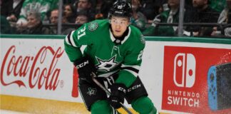 Jason Robertson skating in a Dallas Stars home jersey beside Coca-Cola and Nintendo Switch rink board ads for his 2026-27 fantasy hockey projection
