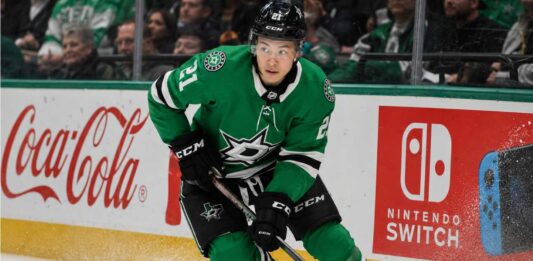 Jason Robertson Point Projections 2026-27: Will the Dallas Stars Star Reach 100? Jason Robertson skating in a Dallas Stars home jersey beside Coca-Cola and Nintendo Switch rink board ads for his 2026-27 fantasy hockey projection