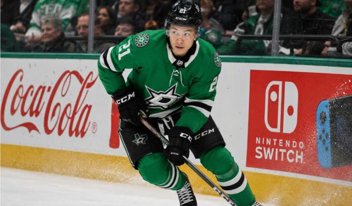 Jason Robertson skating in a Dallas Stars home jersey beside Coca-Cola and Nintendo Switch rink board ads for his 2026-27 fantasy hockey projection