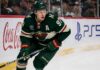 Kirill Kaprizov skating in a Minnesota Wild home jersey beside Coca-Cola and PS5 rink-board ads for a 2026-27 Fantasy Hockey projection
