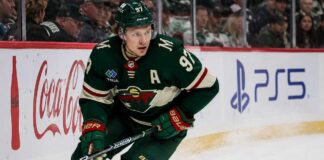 Kirill Kaprizov skating in a Minnesota Wild home jersey beside Coca-Cola and PS5 rink-board ads for a 2026-27 Fantasy Hockey projection