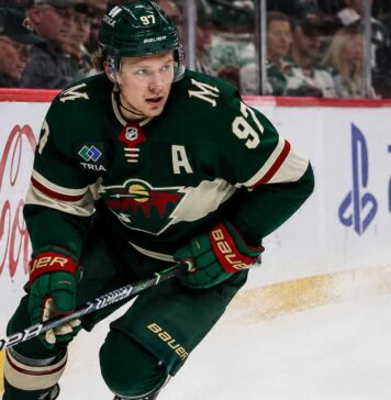 Kirill Kaprizov skating in a Minnesota Wild home jersey beside Coca-Cola and PS5 rink-board ads for a 2026-27 Fantasy Hockey projection