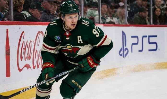 Kirill Kaprizov skating in a Minnesota Wild home jersey beside Coca-Cola and PS5 rink-board ads for a 2026-27 Fantasy Hockey projection