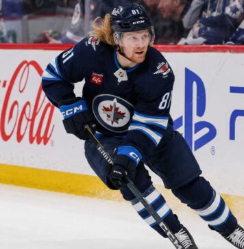 Kyle Connor Fantasy Hockey Projection: Can the Winnipeg Jets Star Reach 100 Points? Kyle Connor skating in a Winnipeg Jets home jersey beside Coca-Cola and PS5 board ads for a 2026-27 Fantasy Hockey projection.