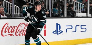 Macklin Celebrini skating for the San Jose Sharks with Coca-Cola and PS5 board ads, highlighting his 2026-27 fantasy hockey point projection