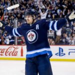Mark Scheifele Point Projections 2026-27: Winnipeg Jets Fantasy Hockey Outlook Mark Scheifele celebrates for the Winnipeg Jets with Coca-Cola and PS5 board ads in a 2026-27 fantasy hockey point projections preview