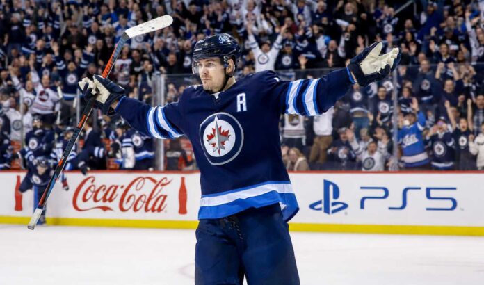 mark-scheifele-2026-27-fantasy-hockey-projection-winnipeg-jets Mark Scheifele celebrates for the Winnipeg Jets with Coca-Cola and PS5 board ads in a 2026-27 fantasy hockey point projections preview