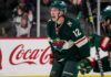 Matt Boldy Point Projections 2026-27: Minnesota Wild Fantasy Outlook Matt Boldy celebrating in a Minnesota Wild jersey beside a Coca-Cola board ad for his 2026-27 fantasy hockey point projection.