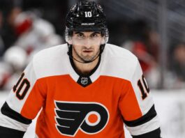 Matty Beniers wearing a Philadelphia Flyers home jersey and helmet amid NHL trade rumors linking the Seattle Kraken center to Philadelphia.