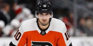 Matty Beniers wearing a Philadelphia Flyers home jersey and helmet amid NHL trade rumors linking the Seattle Kraken center to Philadelphia.